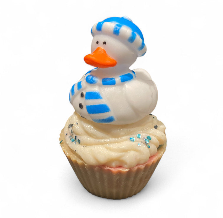 Cupcake with a duck figurine wearing a blue hat and scarf on a white background