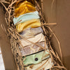 Assorted colorful soap bars in a box with straw padding