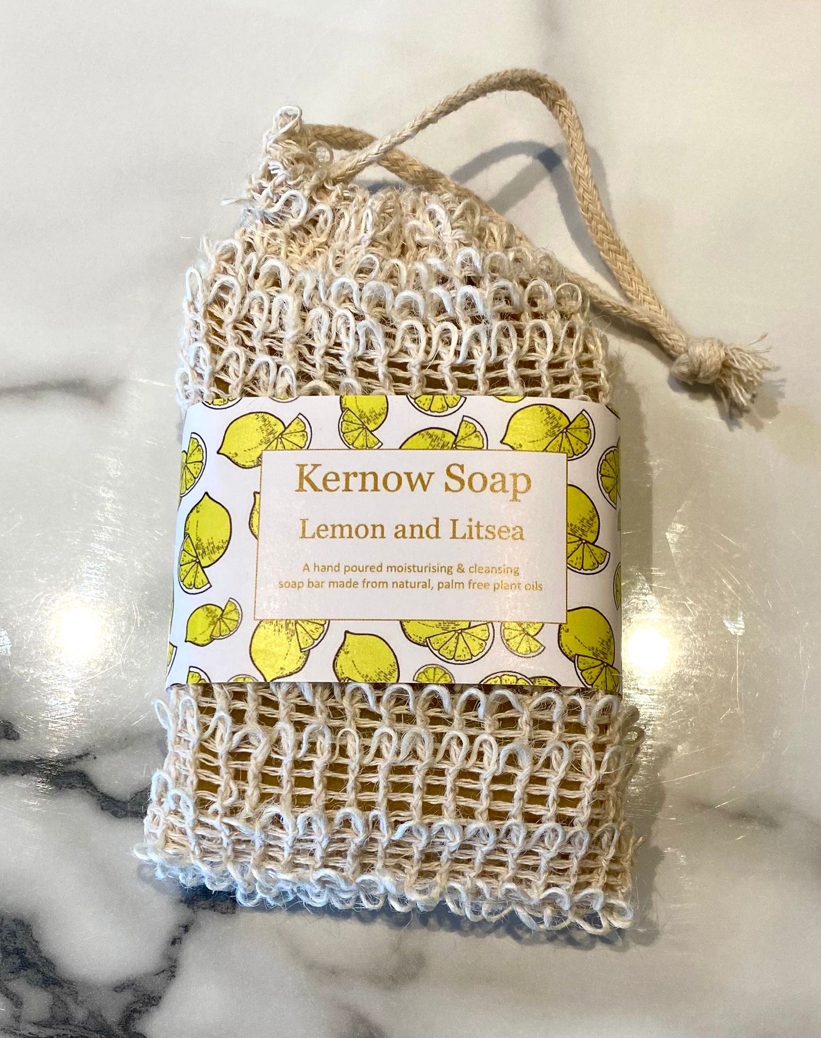 A bar of lemon litsea soap in a sisal bag.