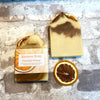 Two bars of turmeric orange  Kernow soap, one labeled, one unlabelled.