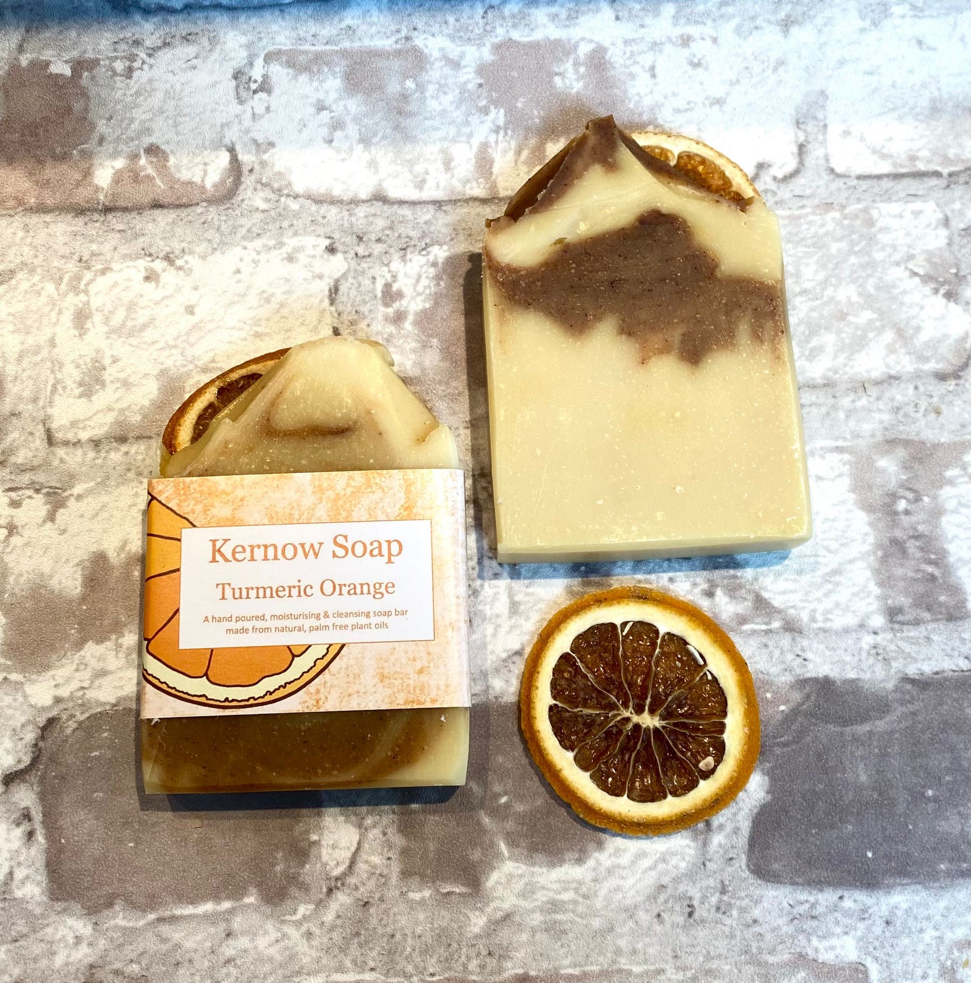 Two bars of turmeric orange  Kernow soap, one labeled, one unlabelled.