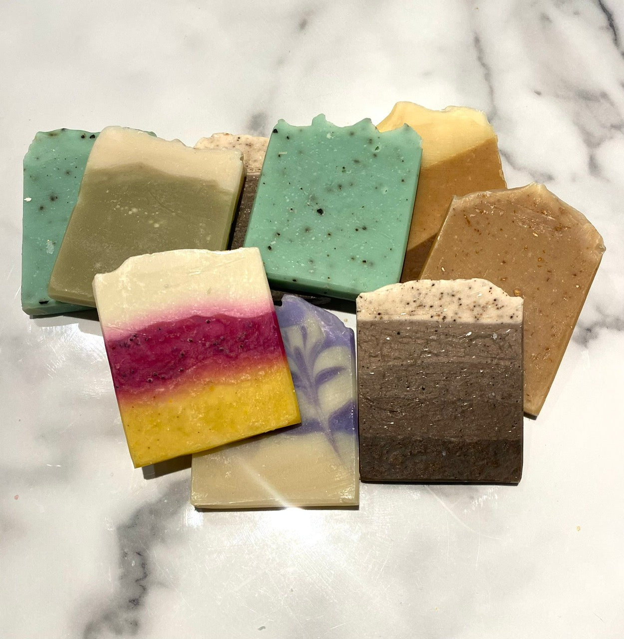 Assorted colorful soap bars on a marble surface
